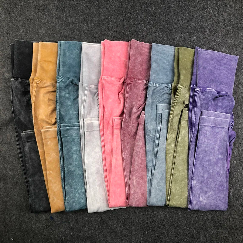 Row of folded colorful pants on a dark textured surface