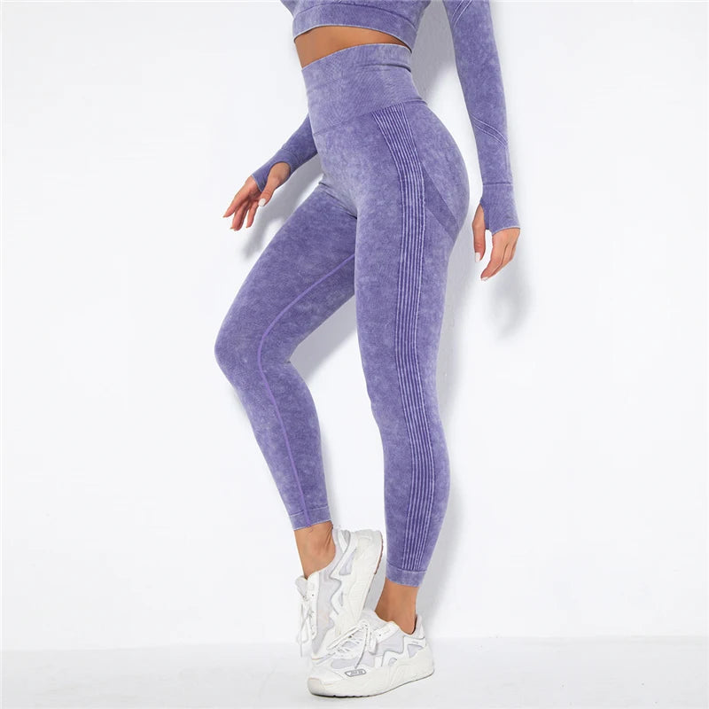 Person wearing a purple athletic outfit with leggings and a long-sleeve top on a white background