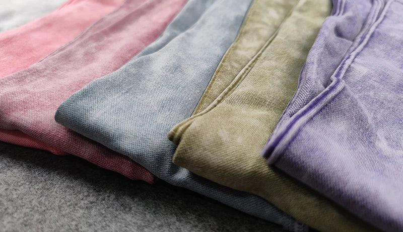 Stack of folded fabric swatches in various colors on a gray surface