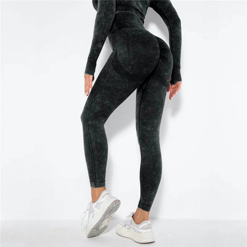 Person wearing black leggings and a matching top on a white background