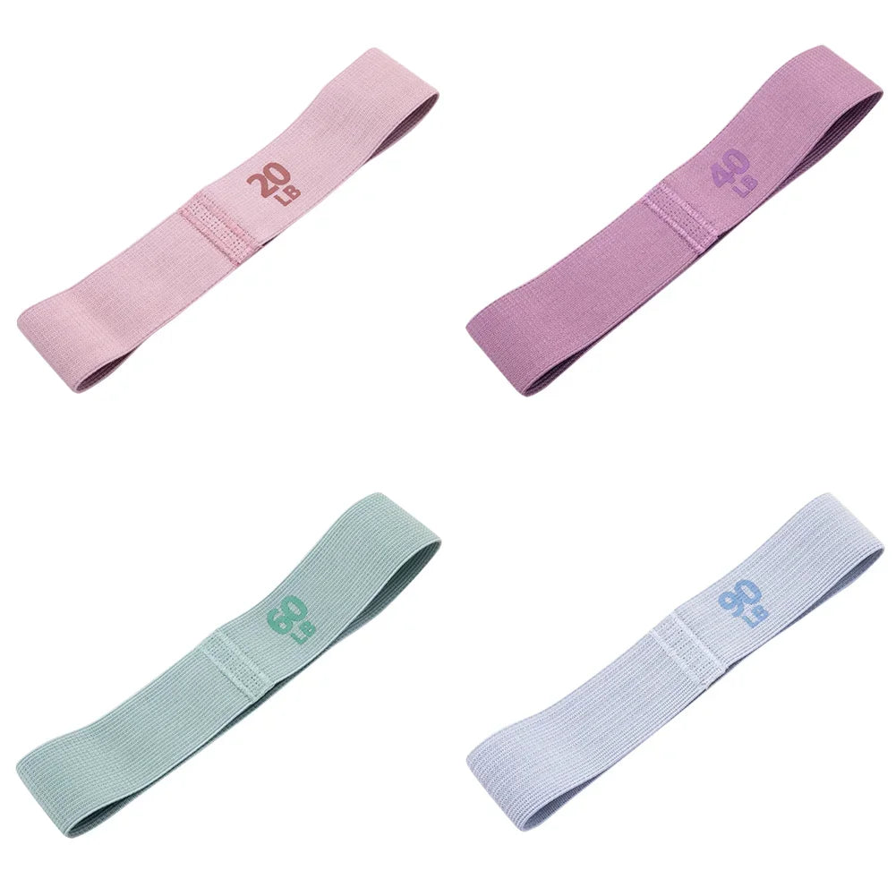 Four resistance bands in pink, purple, green, and blue on a white background