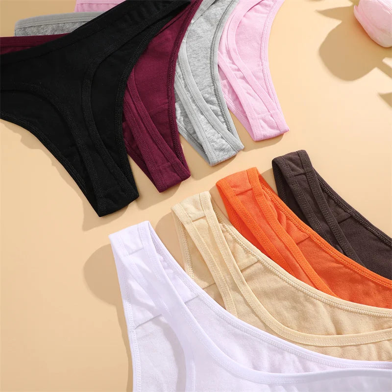 Collection of colorful underwear on a beige surface