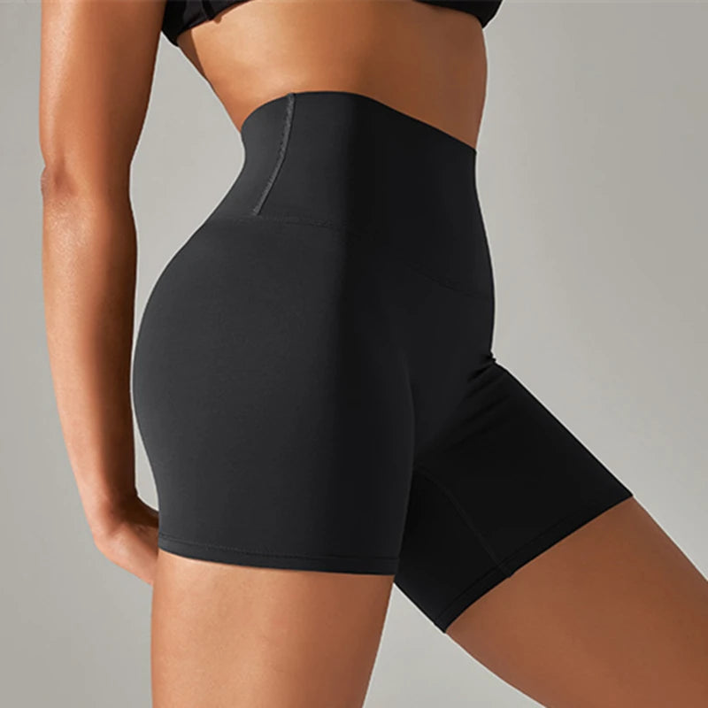 Black high-waisted shorts worn by a person on a neutral background