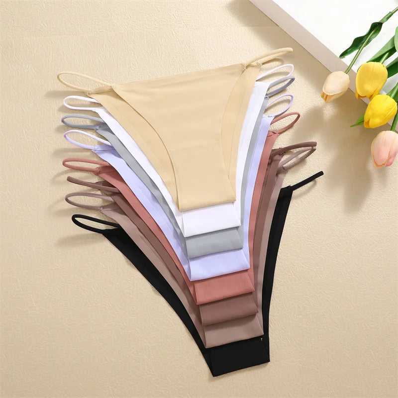Set of women's underwear in various colors on a beige background with tulips.