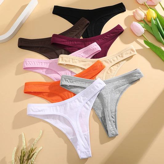 Assorted colors of women's underwear on a beige surface with flowers.