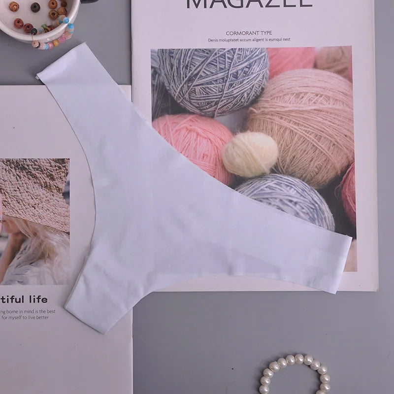 White fabric strip on a magazine with yarn balls and knitting images.